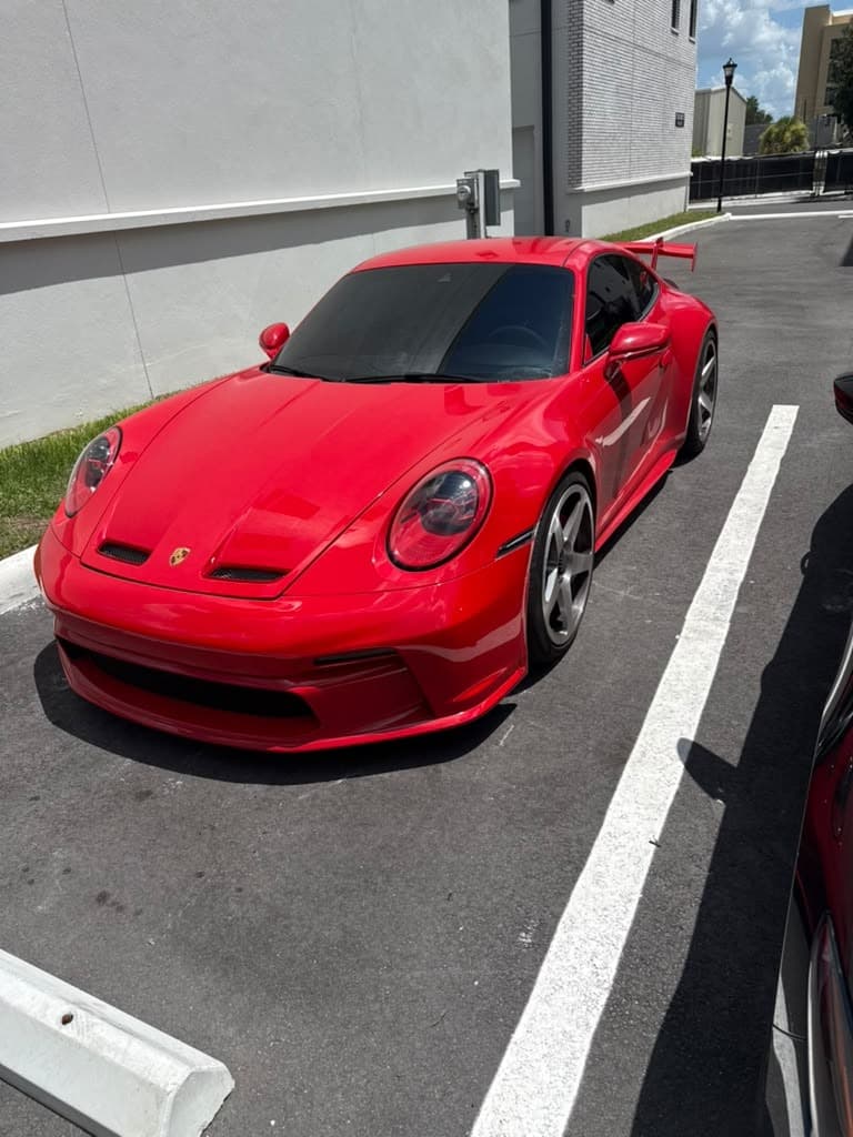 A red Porsche 911 finished with Formula 1051, deep gloss holding across the front fascia