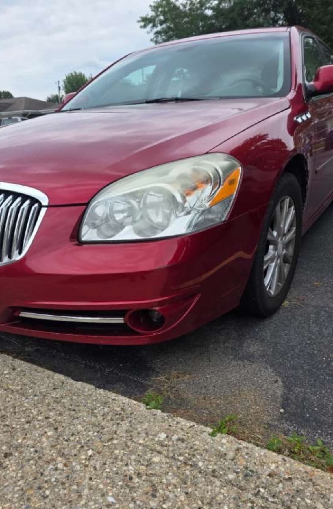 The same red bumper corner after correction, the scuff gone and the gloss even
