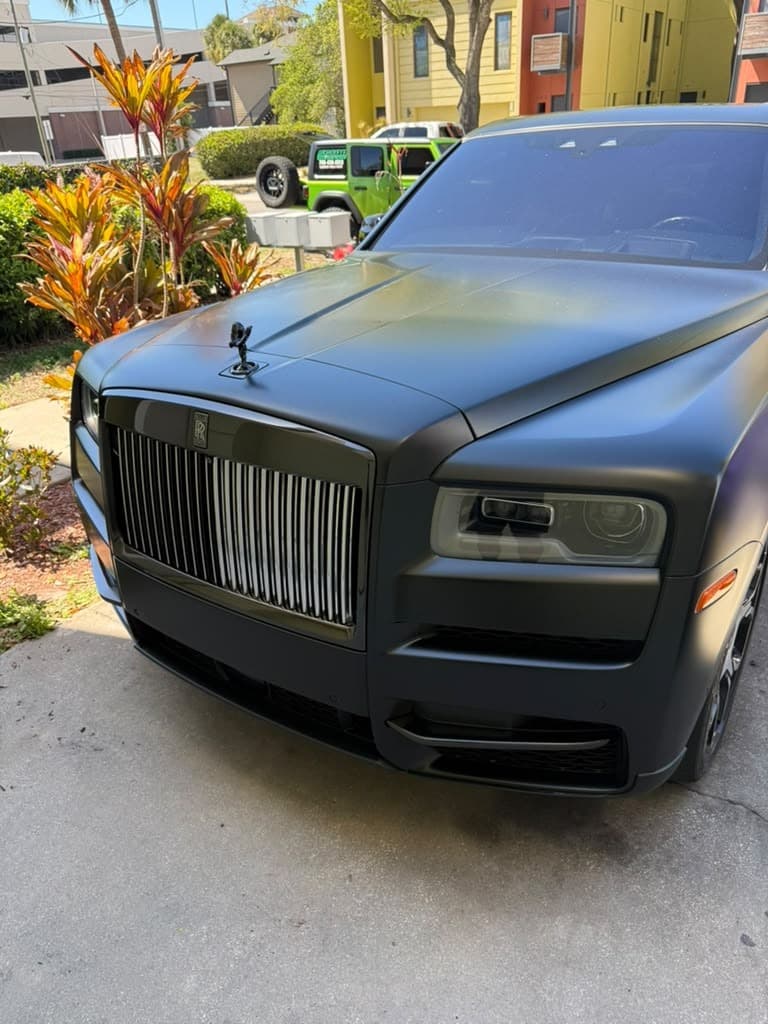 Close-up of a matte black Rolls-Royce grille and hood after detailing